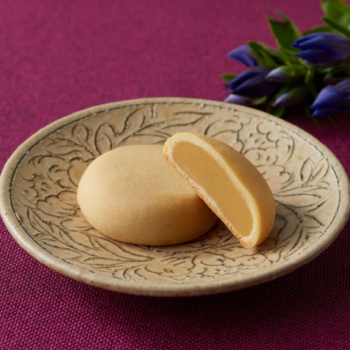 新宿中村屋　月の菓（みるくまんじゅう）の断面写真。北海道産生クリームを使用したミルク風味の自家製餡のしっとり食感が伝わるシズル画像